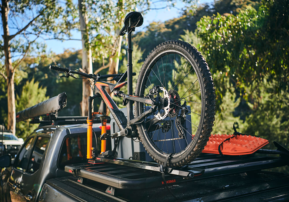 A mountain bike in a Yakima High Road bike carrier, mounted to a LockNLoad platform rack on a pickup