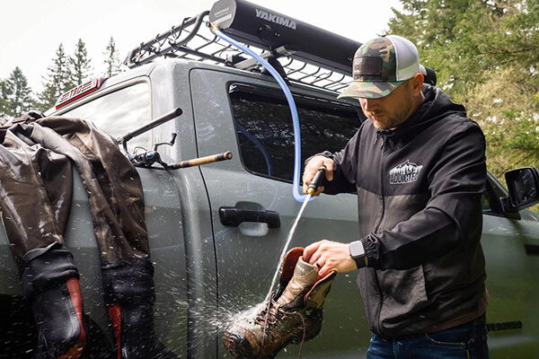 Man washes his boots with the Yakima Road Shower